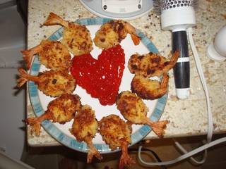 A plate of fried frog legs arranged around a red heart-shaped food center.