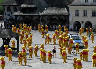 Dozens of identical toy figures are arranged in a yard.