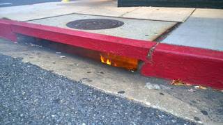 A small flame appears along a curb or street edge.