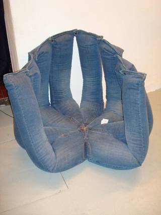 A chair is upholstered to resemble empty blue jeans.