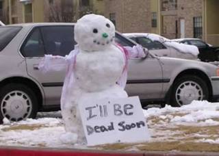 Snowman holding a bleak handwritten sign.