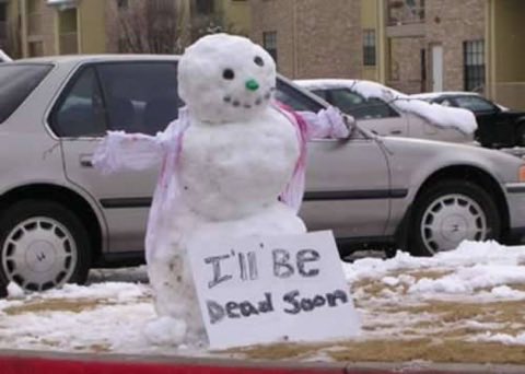 Snowman holding a bleak handwritten sign.