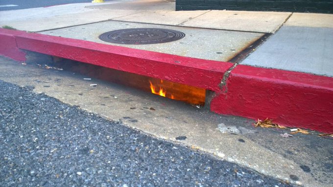 A small flame appears along a curb or street edge.