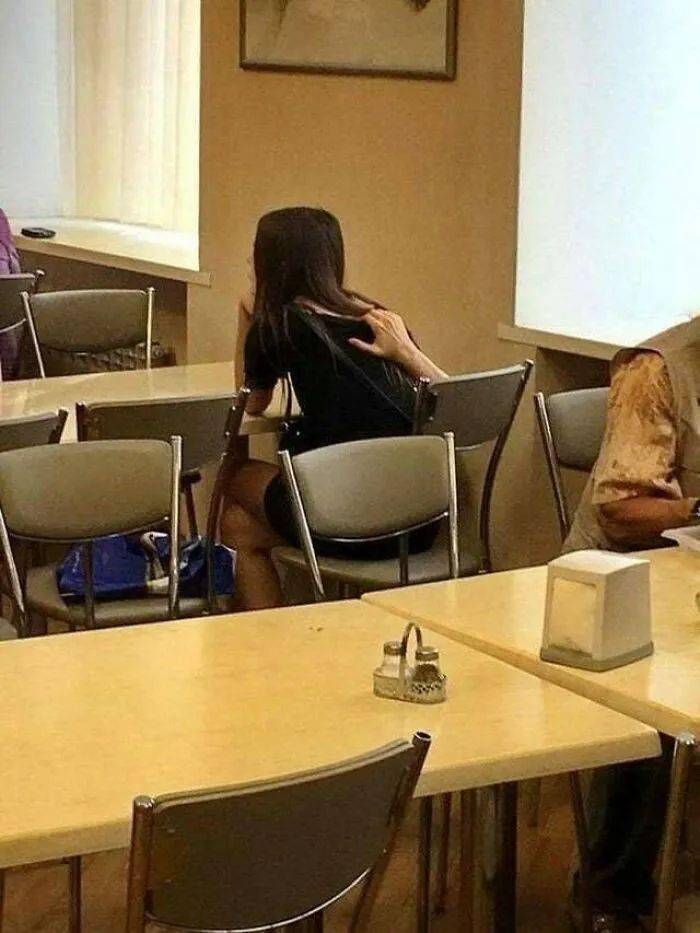 A person sitting at a desk in an otherwise empty classroom.