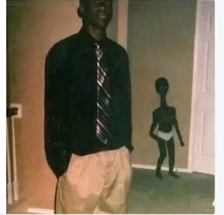 Dark photobomber in a hallway frame.