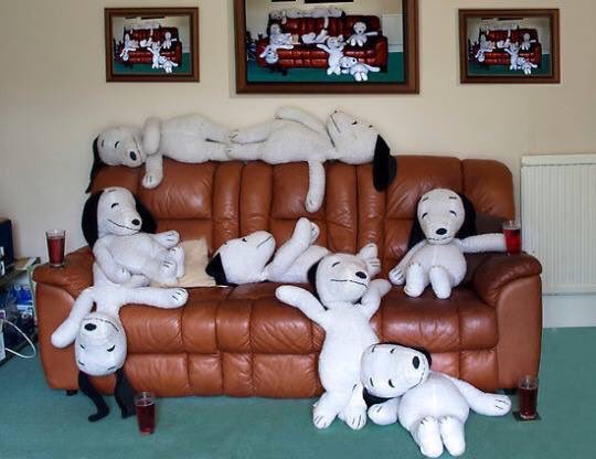 Sofa crowded by white plush figures.