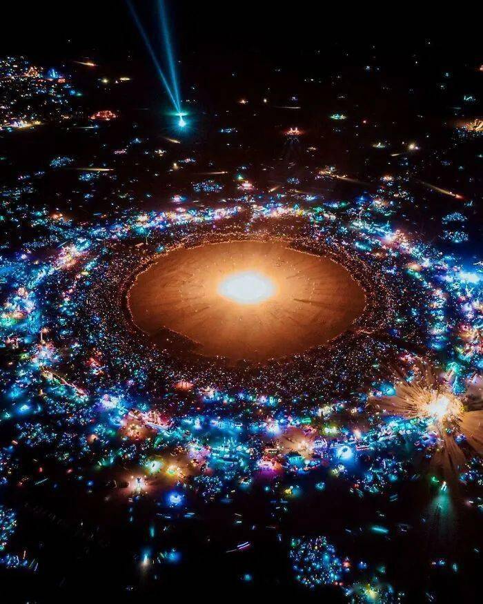 A bright circular glow surrounded by small blue lights in darkness.