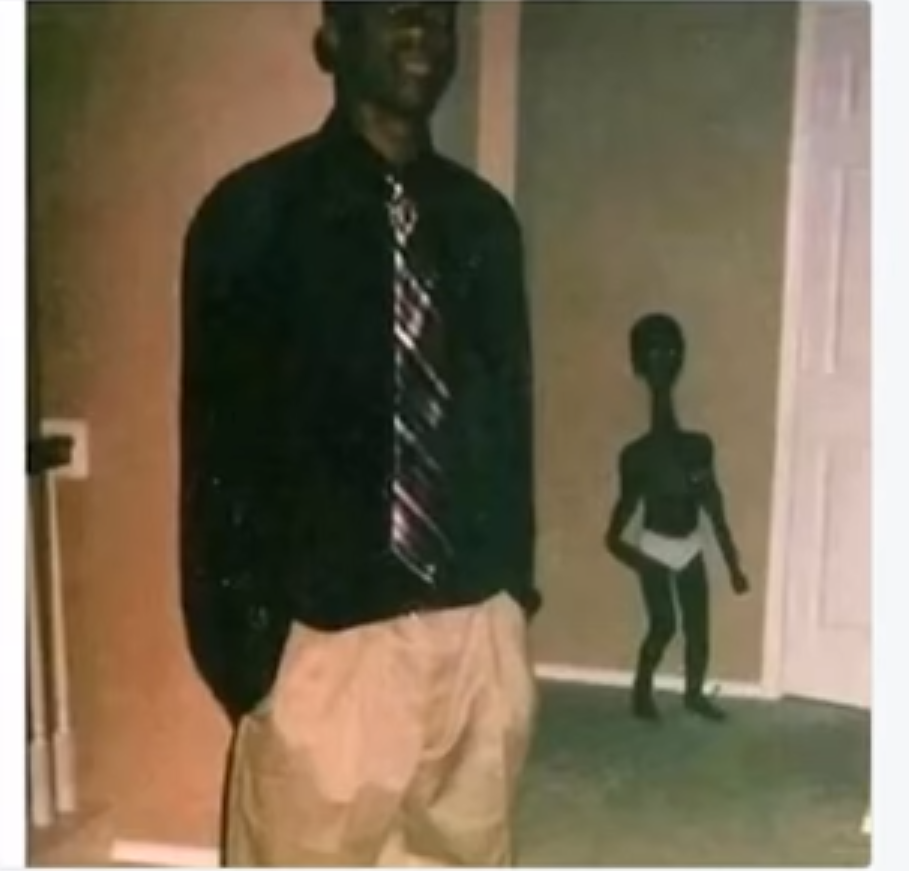 Dark photobomber in a hallway frame.