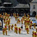 Hundreds of Winnie the Pooh mascots in a town square surrounding a police car.