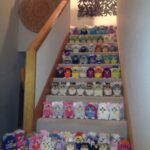 A staircase filled with rows of Furbies neatly organized by color.