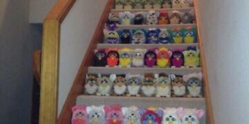 A staircase filled with rows of Furbies neatly organized by color.