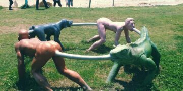 A park sculpture of humans and an iguana connected in a circular loop.