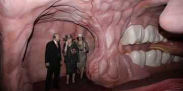 Visitors inside a giant human mouth-themed exhibit, exploring its interior.