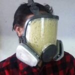 Pasta stuffed inside a gas mask in a strange and cursed setup.